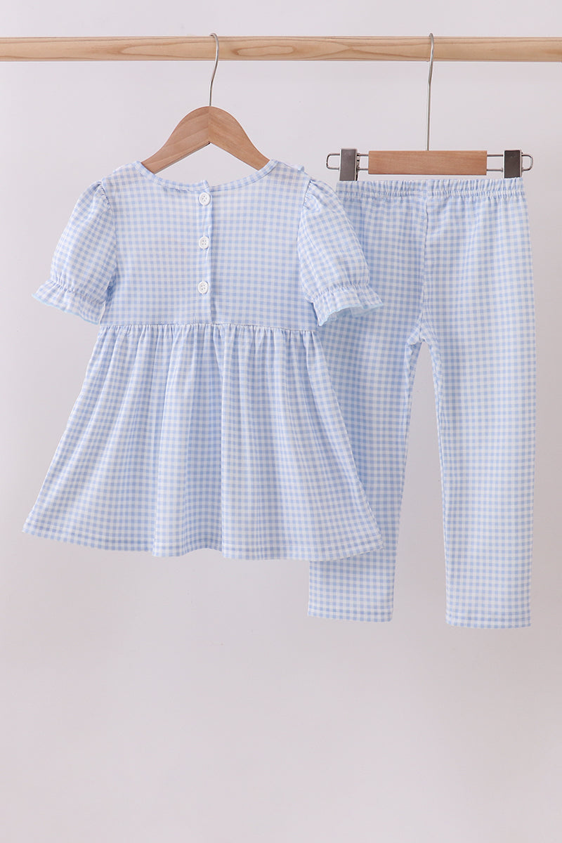 Children's blue checkered outfit on a hanger against a white background