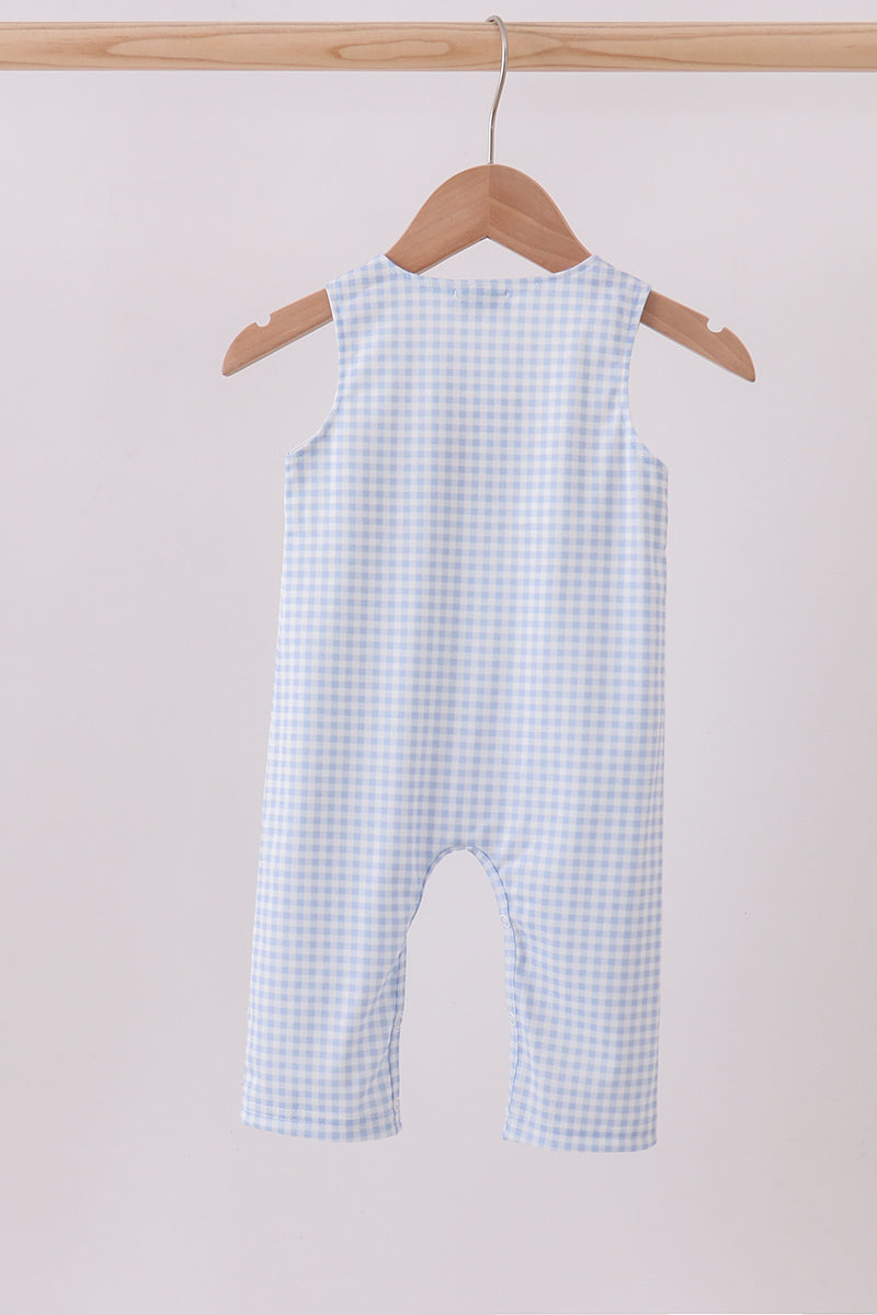 Blue checkered baby romper on a wooden hanger against a light pink background