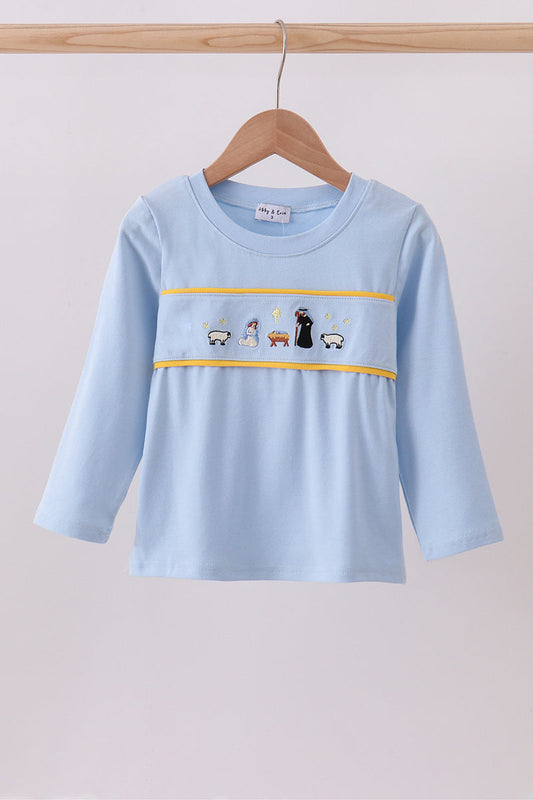 Light blue long-sleeve shirt with embroidered design on a wooden hanger against a light gray background
