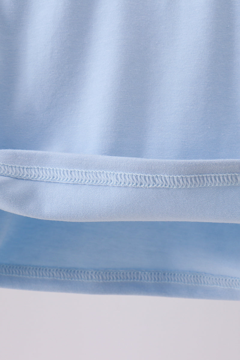 Close-up of light blue fabric with a focus on texture and stitching.