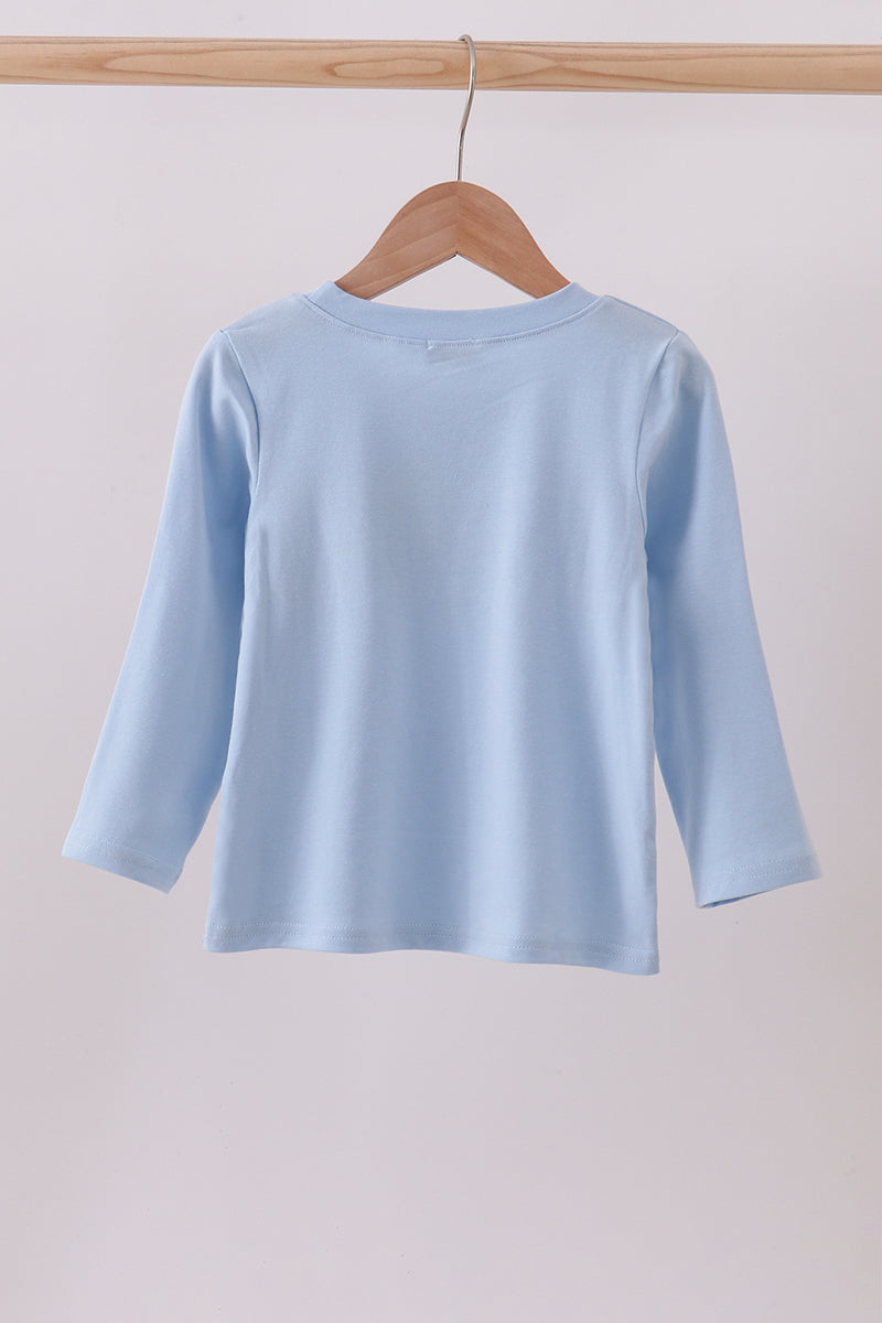 Light blue long-sleeve shirt on a wooden hanger against a plain background