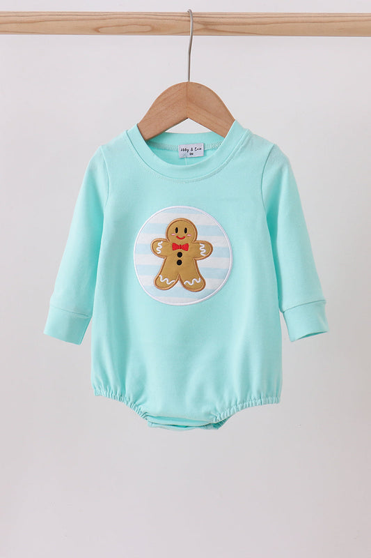 Mint green baby romper with gingerbread man design on a wooden hanger against a white background