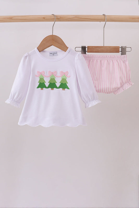 White shirt with tree design and pink shorts on hangers against a white background