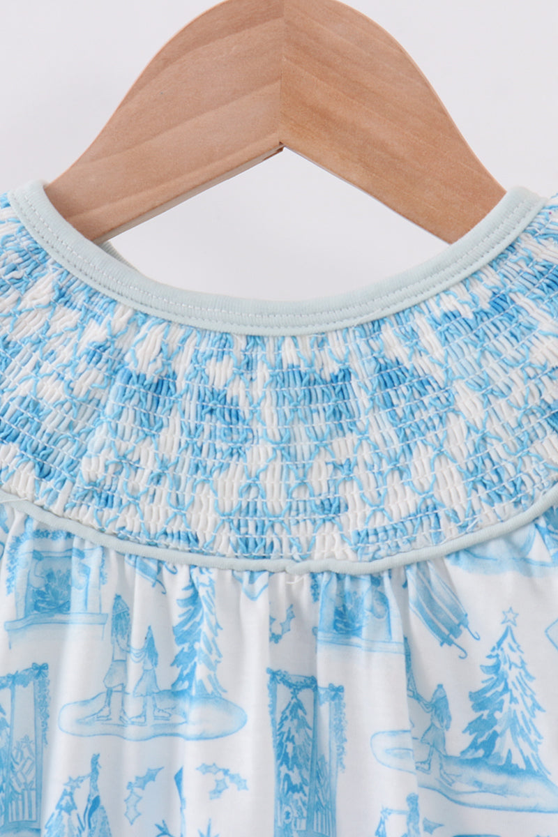 Close-up of a blue and white patterned dress on a wooden hanger against a white background