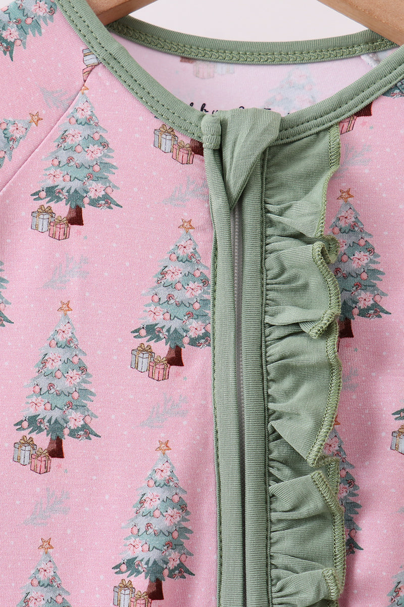 Close-up of a pink outfit with Christmas tree pattern and green trim