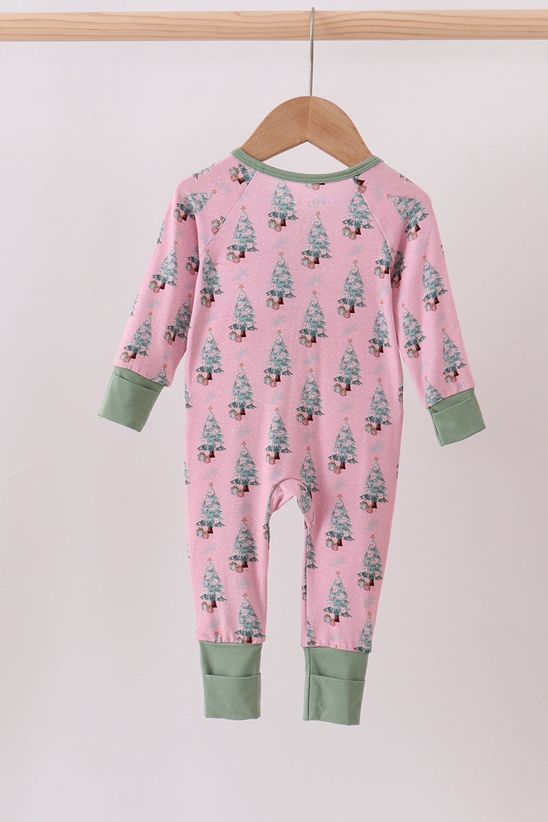 Pink onesie with tree pattern on a hanger against a light pink background
