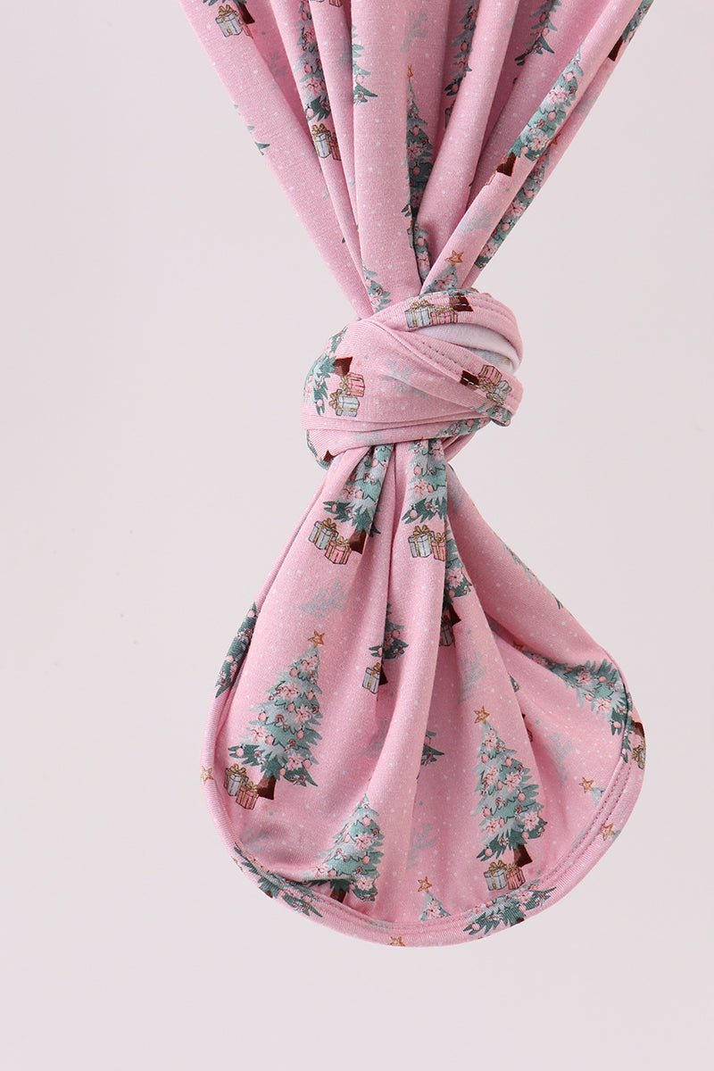 Pink fabric with a floral pattern tied into a knot on a light pink background