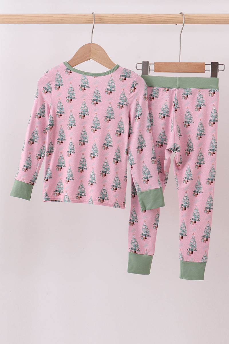 Pink pajama set with tree pattern on hangers against a white background