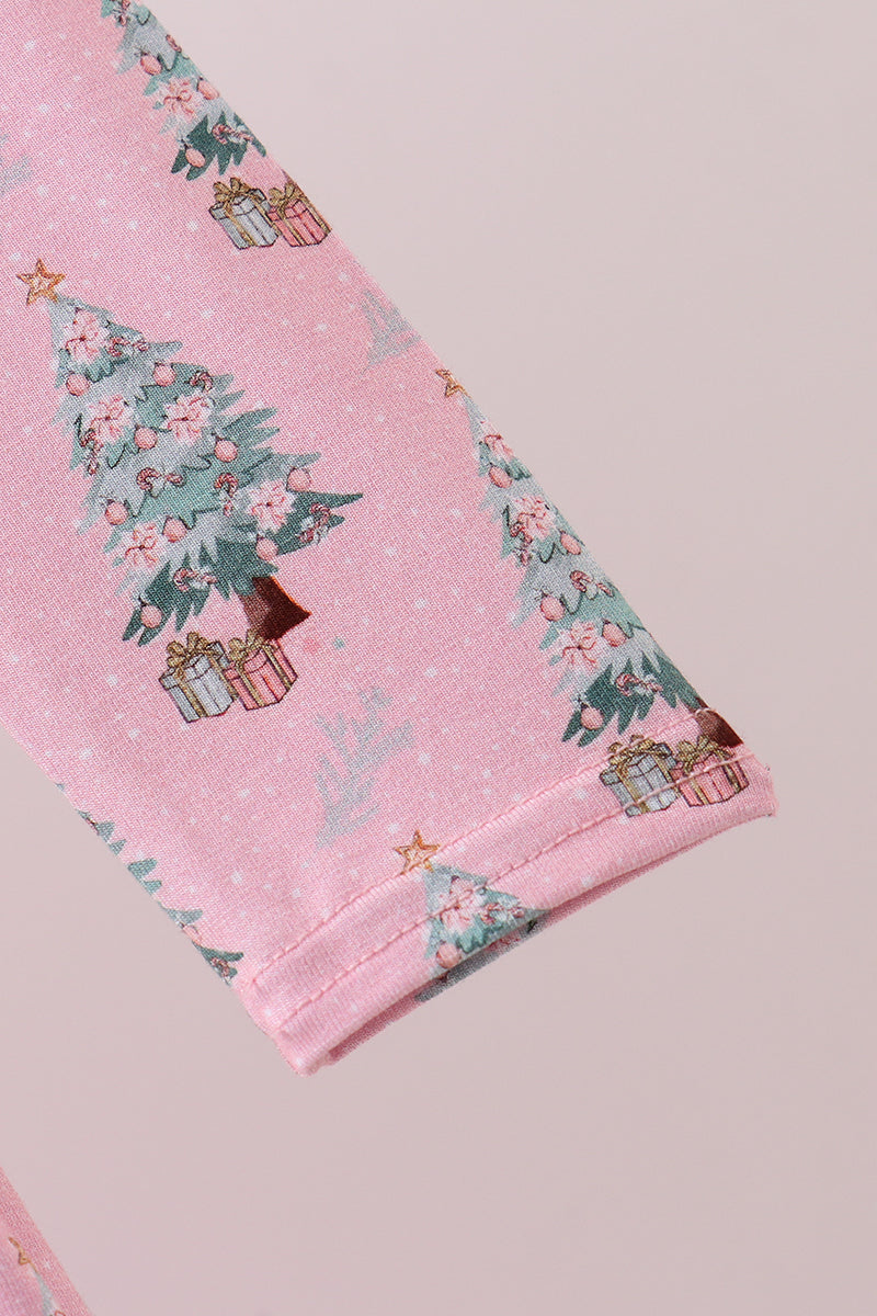 Close-up of pink fabric with Christmas tree and gift pattern