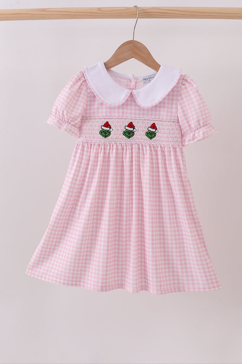 Pink checkered dress with white collar and embroidered details on a hanger against a light background