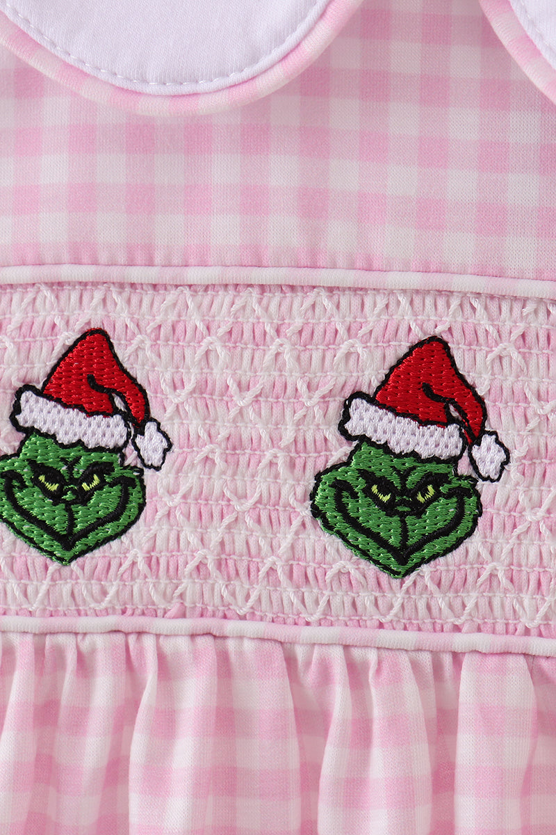Pink checkered dress with embroidered Grinch faces wearing Santa hats.