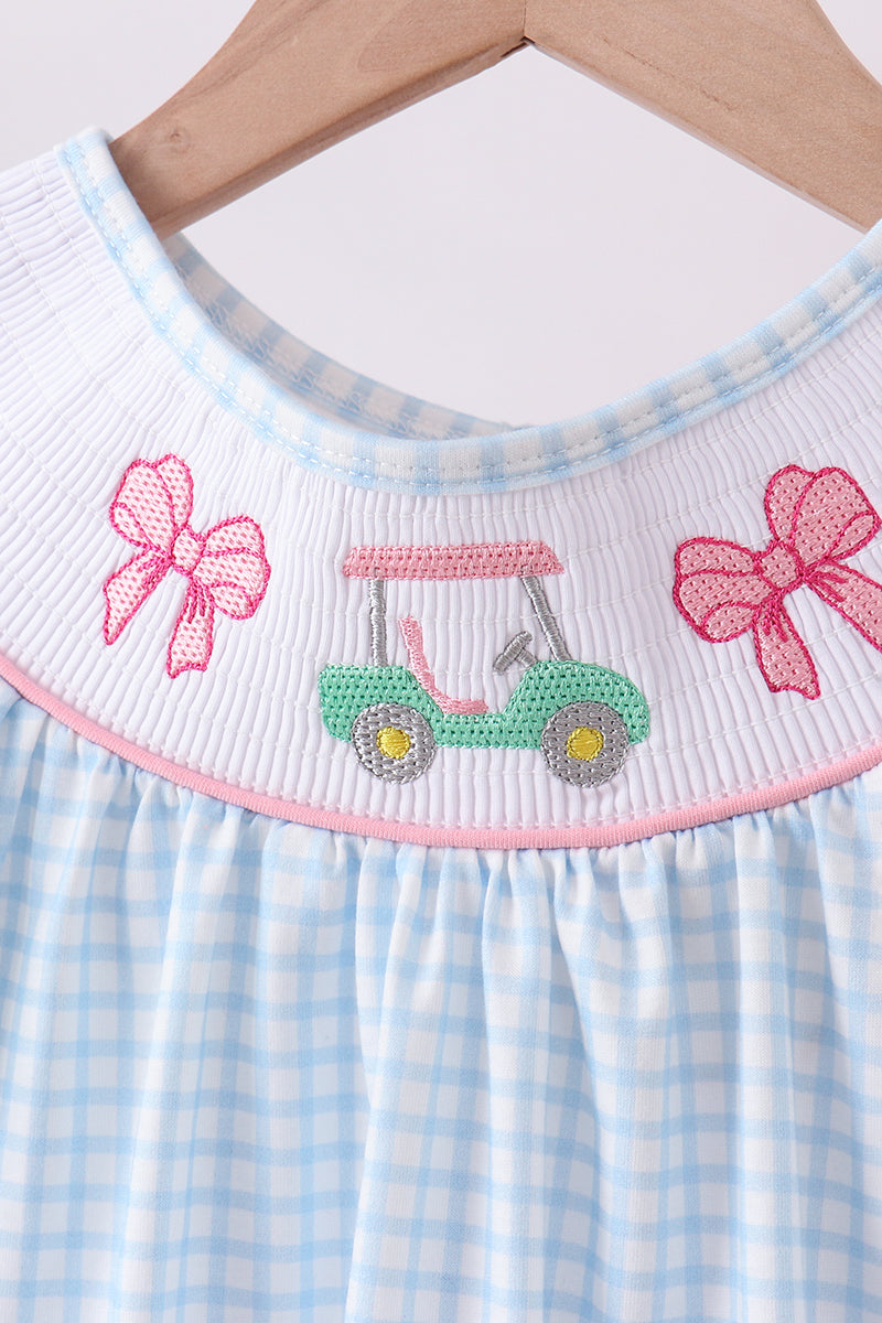 Children's dress with checkered pattern and embroidered design on a white background