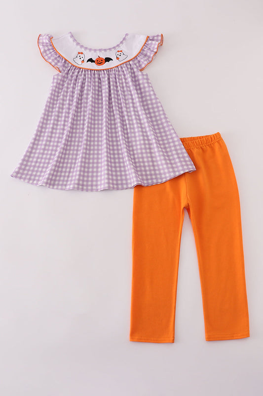 Purple checkered top and orange pants on a light gray background