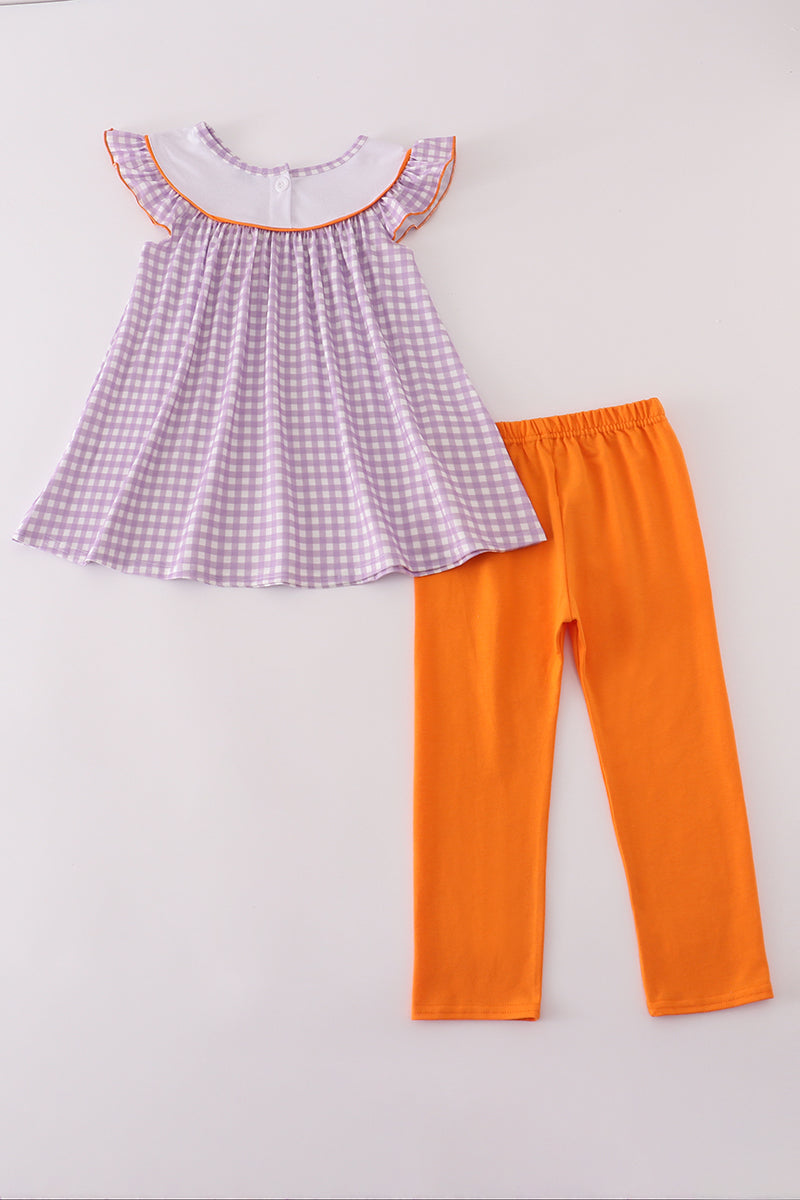 Checkered top and orange pants on a light gray background
