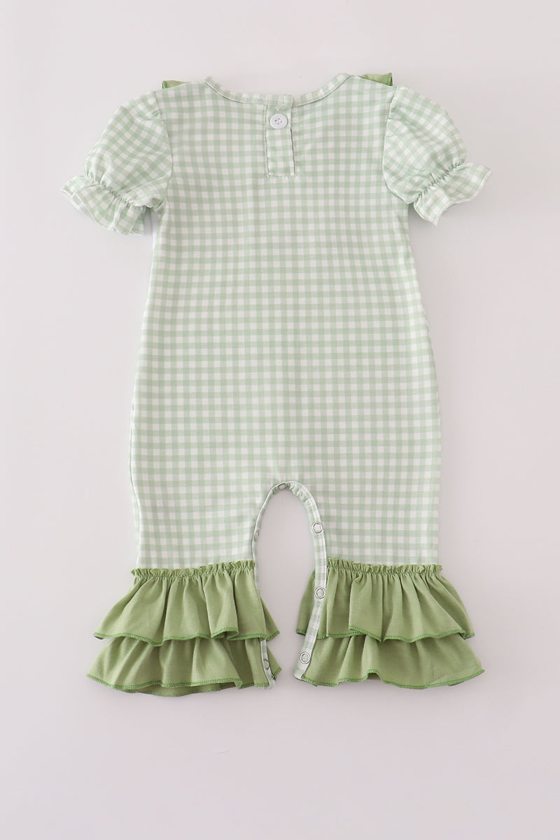 Green checkered dress with ruffled details on a light gray background