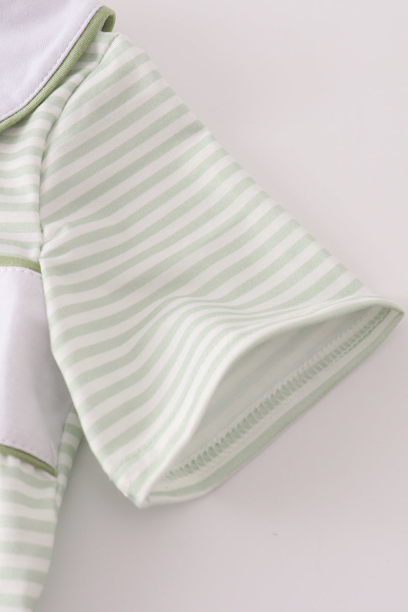 Green and white striped baby outfit on a light gray background