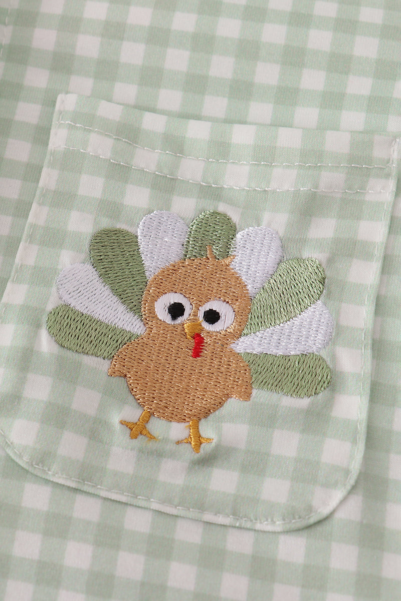 Embroidered turkey patch on a green checkered fabric background