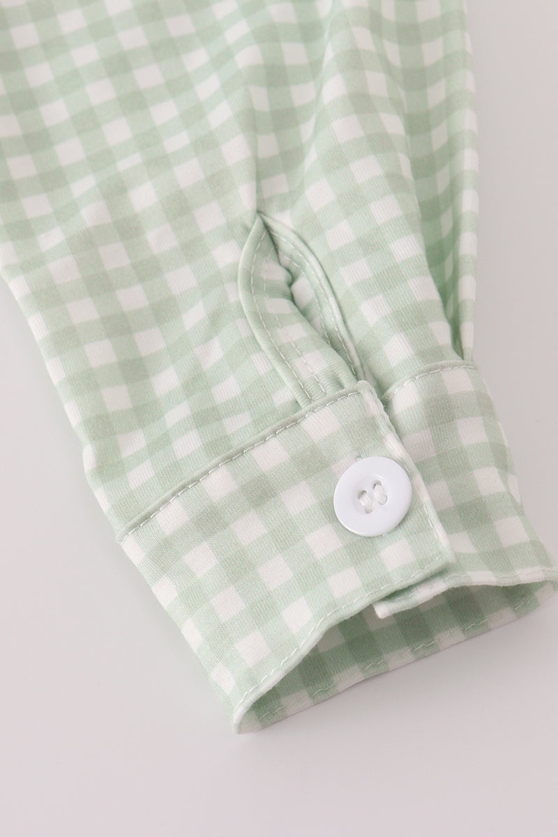 Green and white checkered fabric with a button on a light gray background