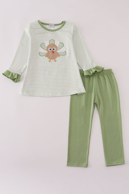 Children's green and white striped shirt with owl design and matching pants on a light pink background