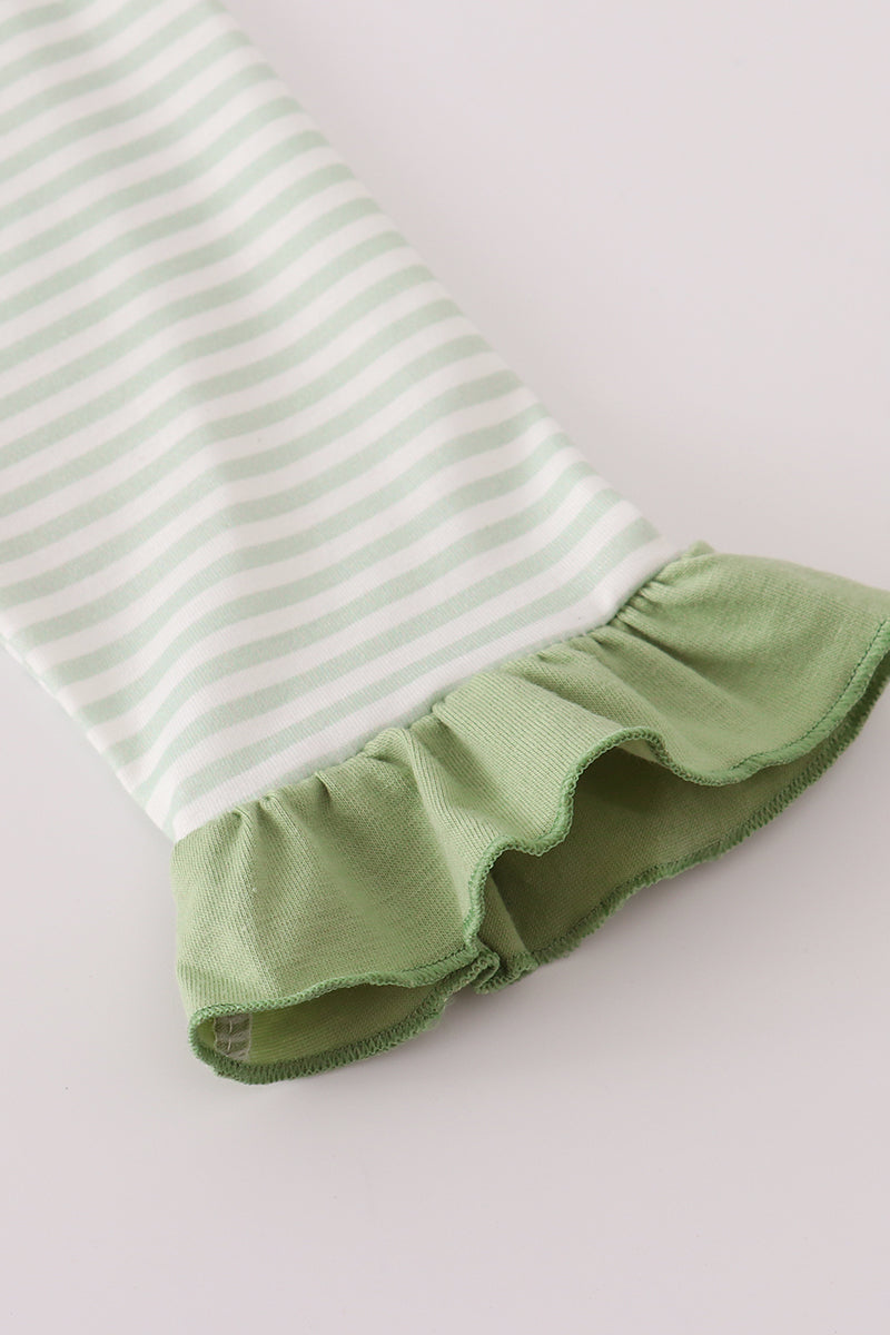 Green and white striped baby romper with ruffled hem on a light gray background