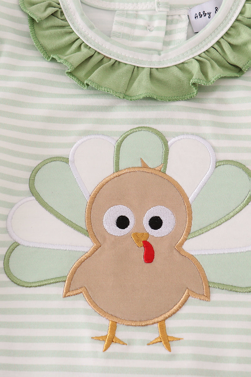 Children's outfit with a turkey applique on a green and white striped background