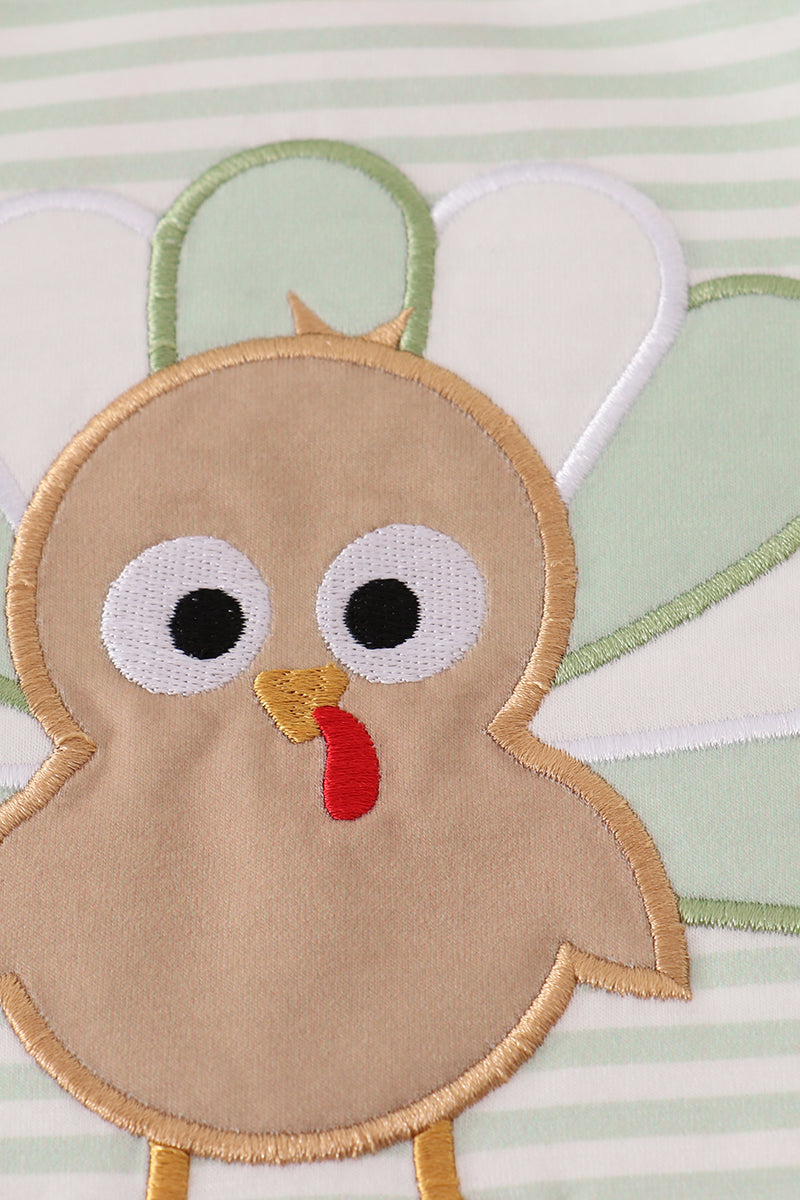 Embroidered turkey design on a fabric background