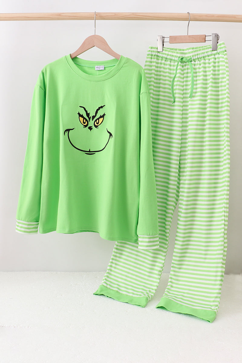 Green pajama set with a face design on a white background