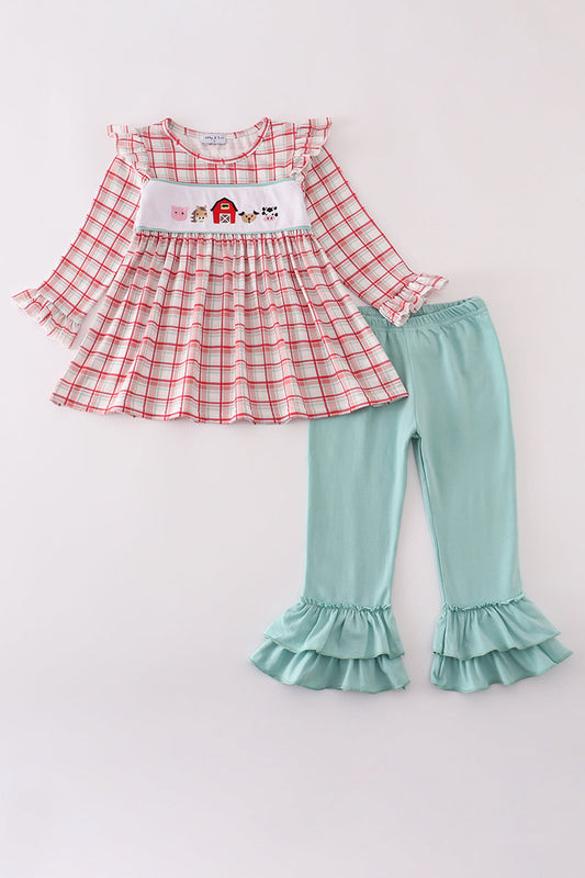 Red plaid top and teal ruffled pants set on a white background