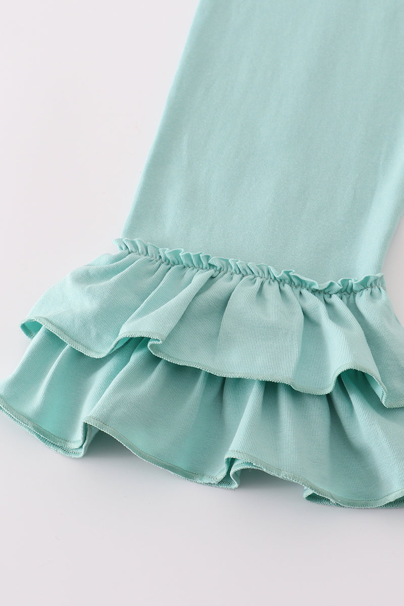 Close-up of a light blue dress with ruffled hem on a white background