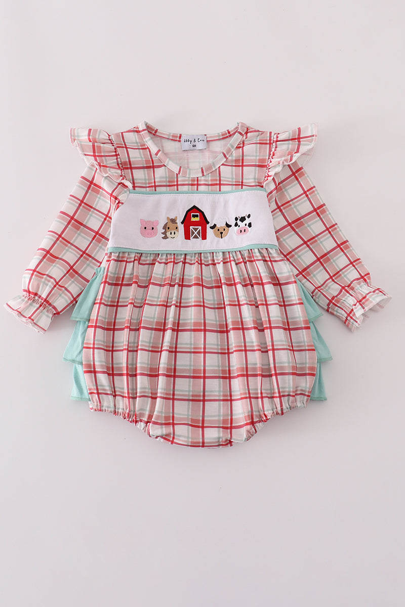 Baby romper with plaid design and farm-themed applique on a light gray background