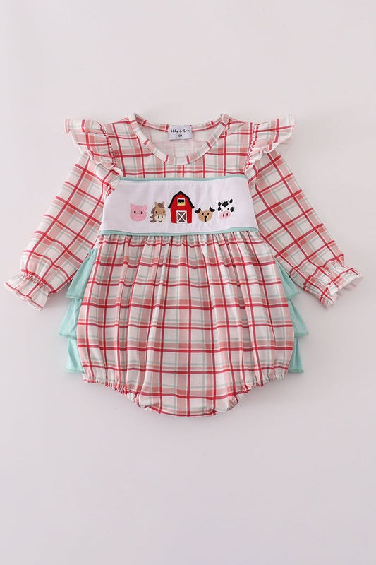 Baby romper with plaid design and farm-themed applique on a light gray background