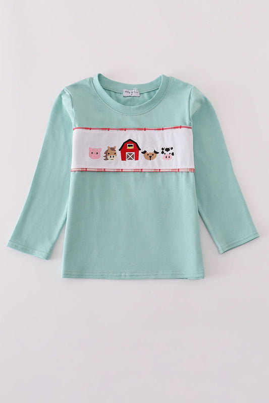 Light blue long-sleeve shirt with farm-themed design on a light gray background