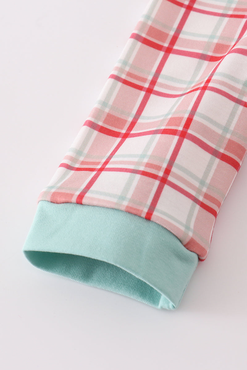 Close-up of a plaid fabric with a green hem on a white background
