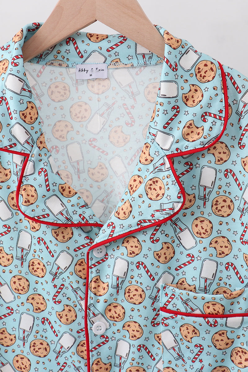 Children's pajama set with cookie and candy cane pattern on a light blue background