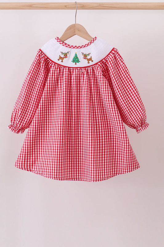 Red checkered dress with embroidered top on a hanger against a beige background