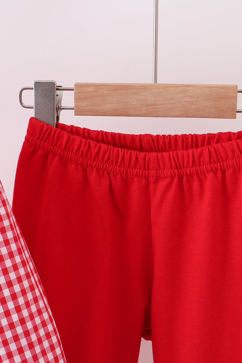 Red shorts on a hanger against a light background