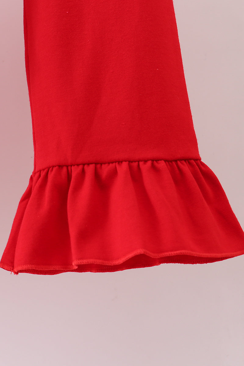 Red dress with a ruffled hem on a light pink background
