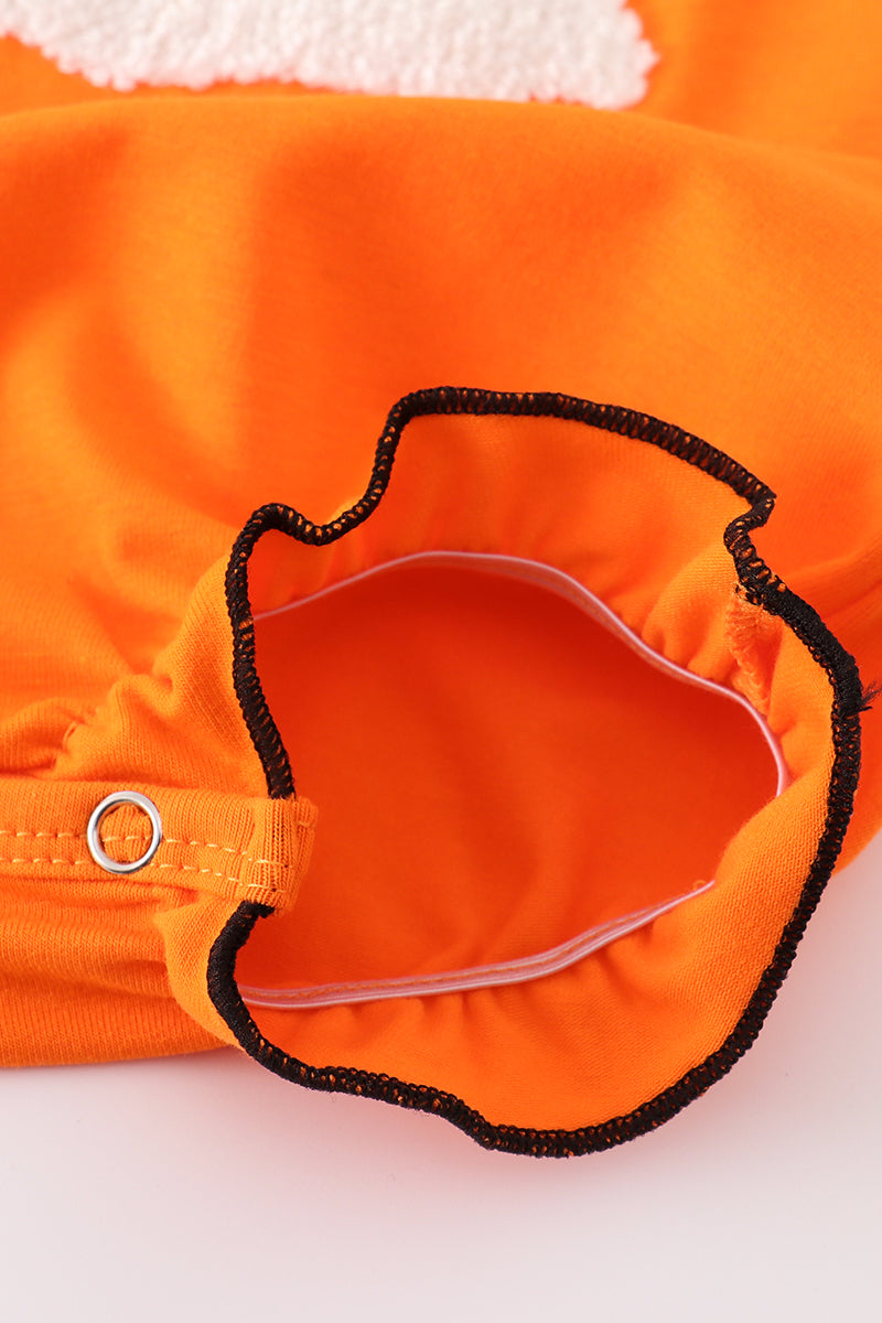 Close-up of an orange garment with a black trim on a white background