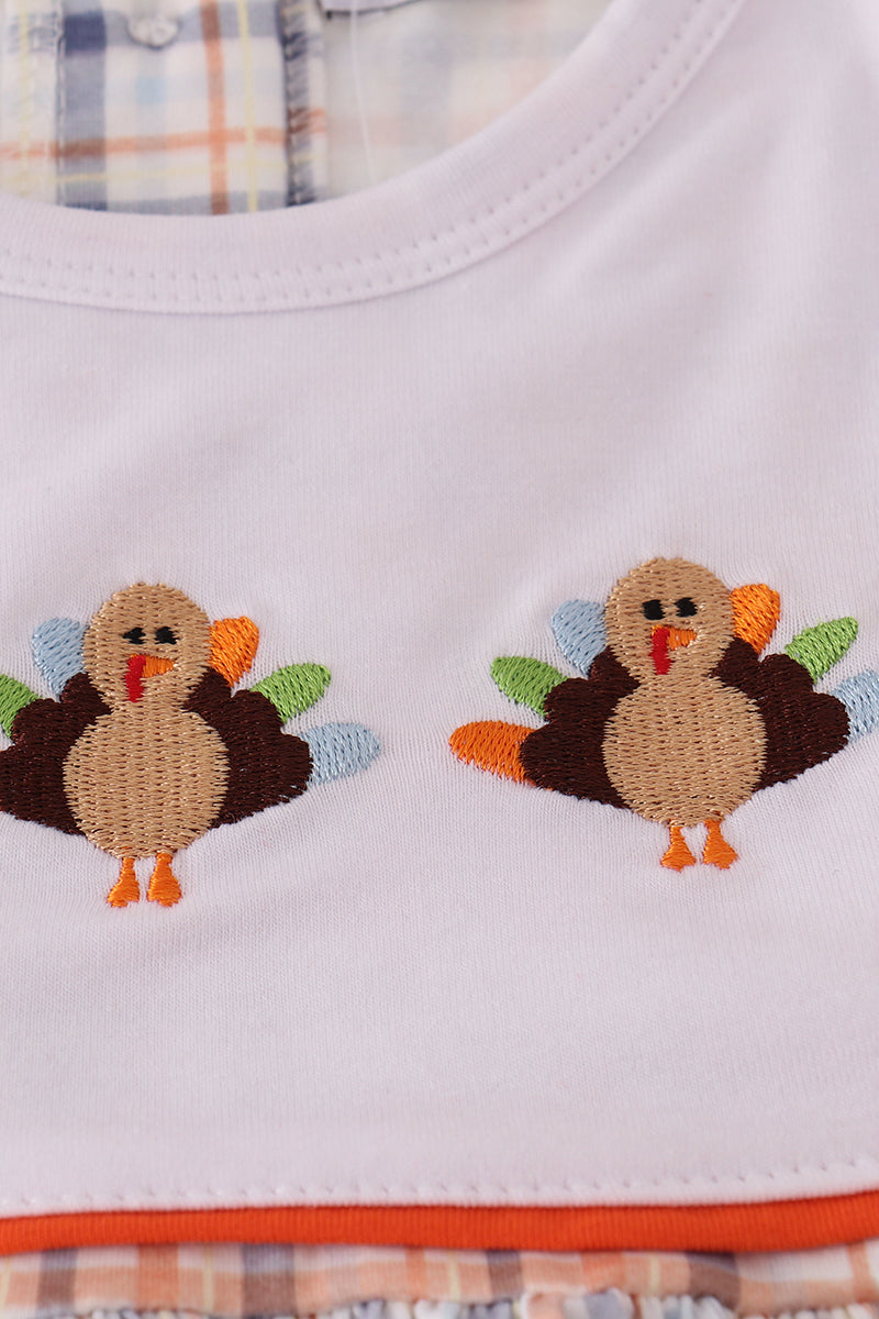 White shirt with embroidered turkeys on a plaid background