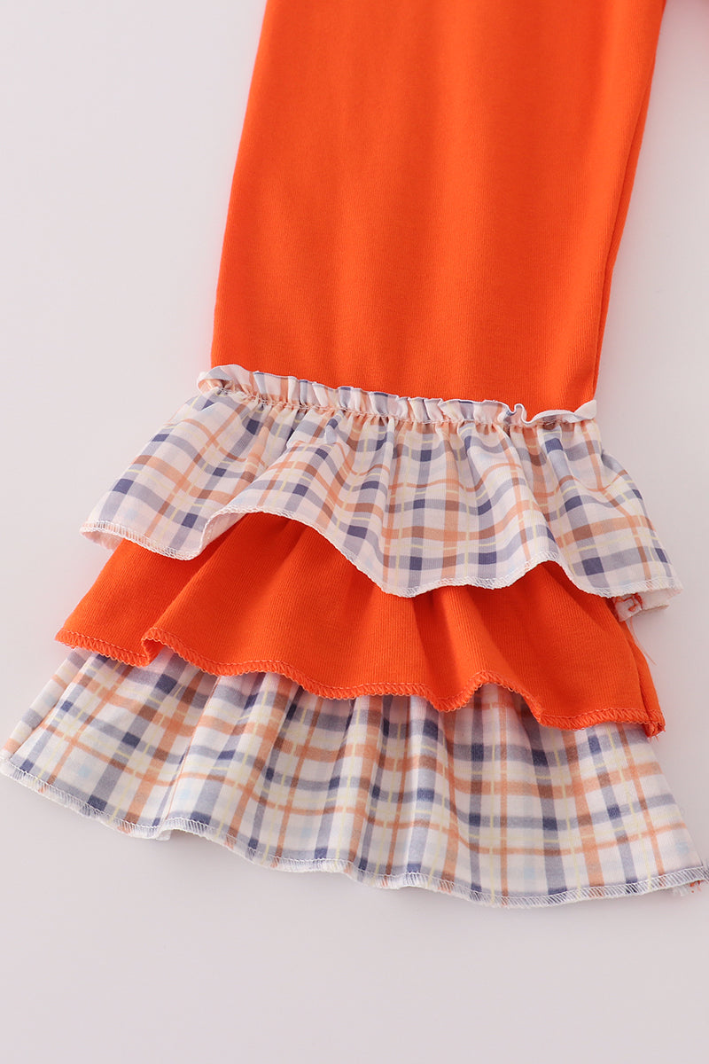 Orange dress with plaid ruffled layers on a white background