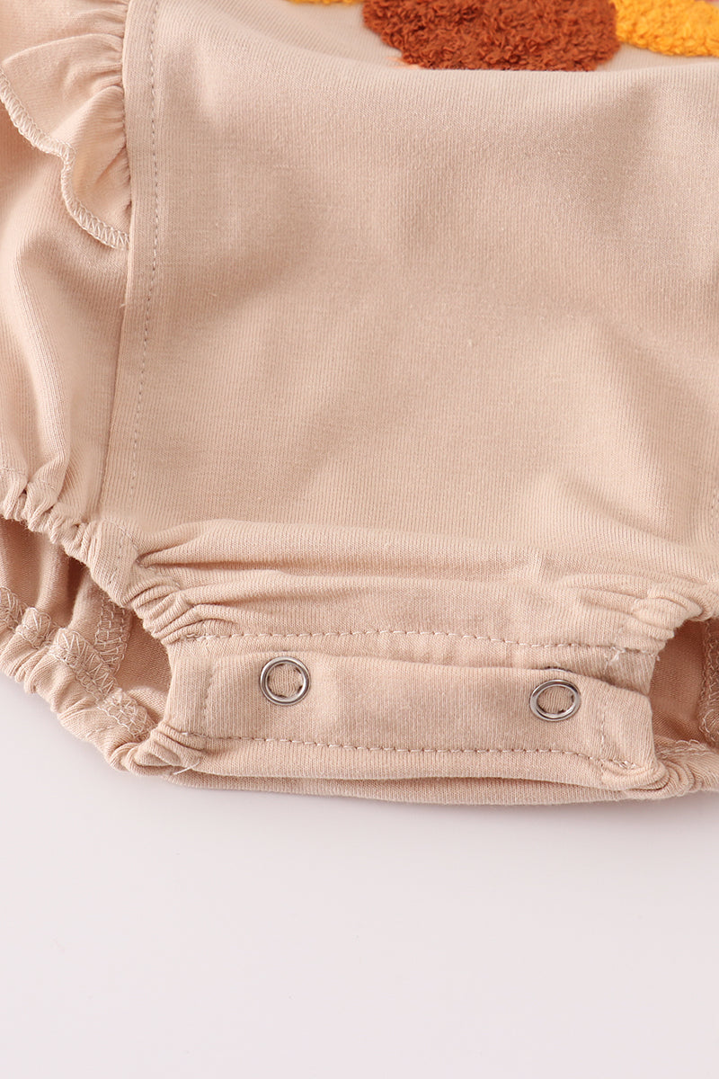 Beige baby bloomers with button closure on a white background