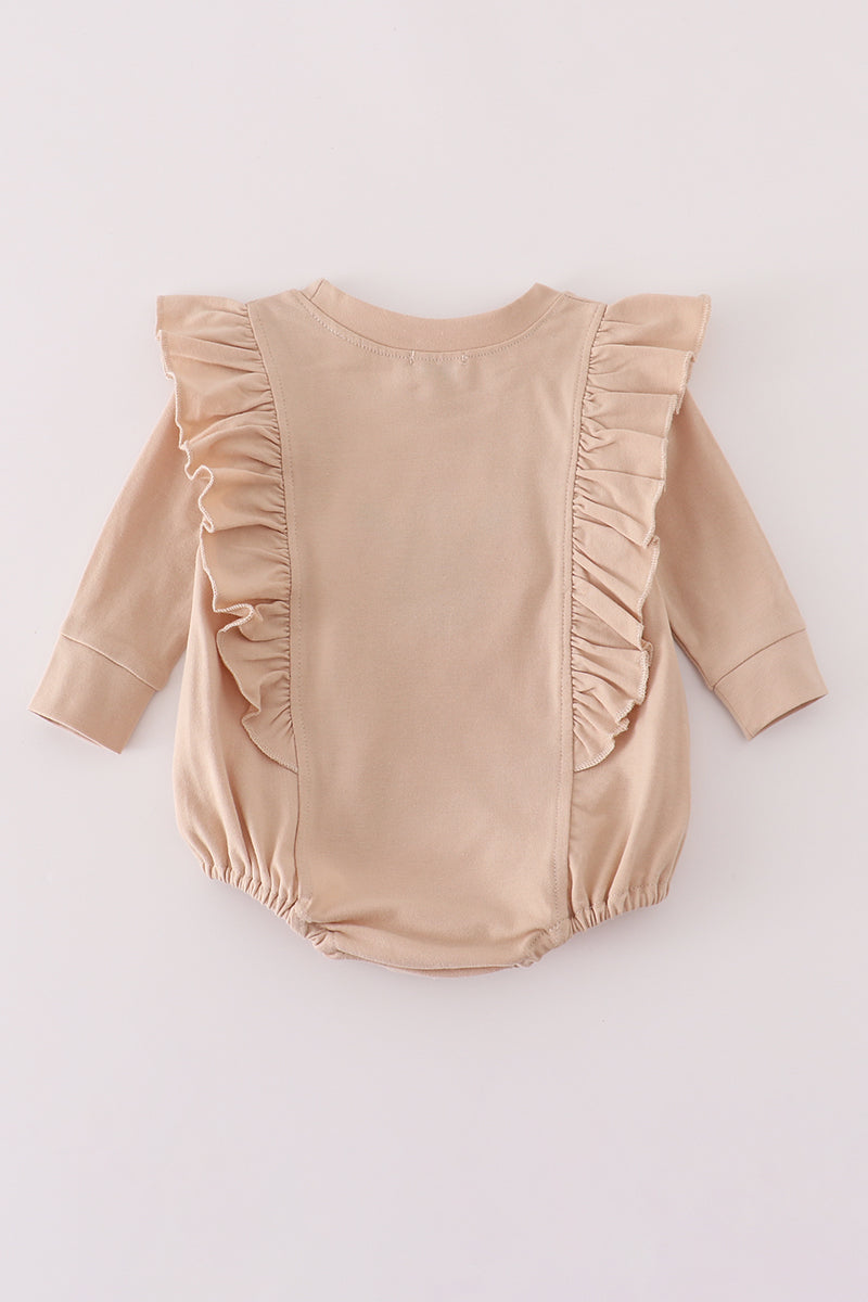 Beige baby romper with ruffled details on a light gray background