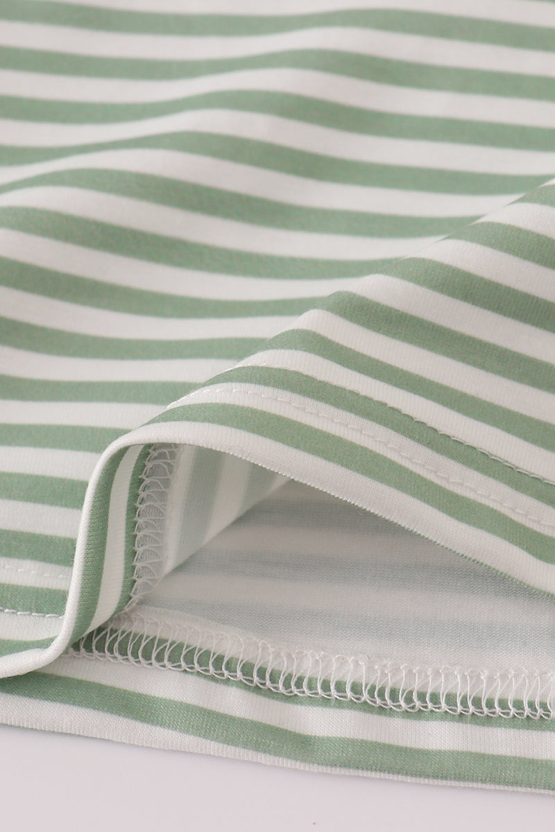 Close-up of green and white striped fabric with a visible seam.