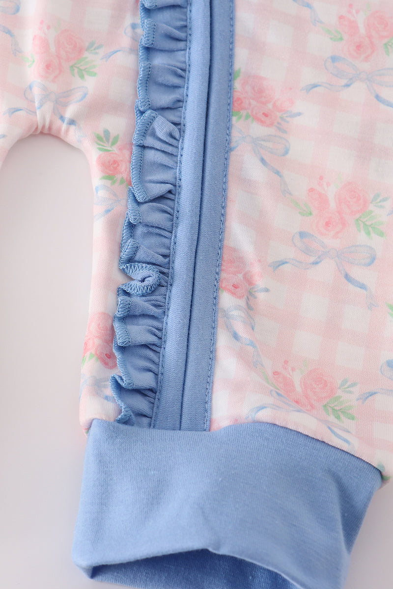 Close-up of a baby outfit with floral pattern and blue trim
