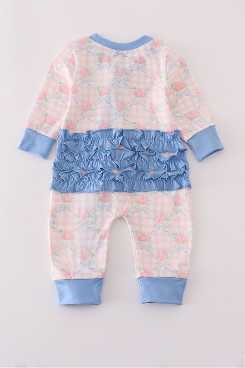 Baby romper with floral pattern and blue accents on a light gray background