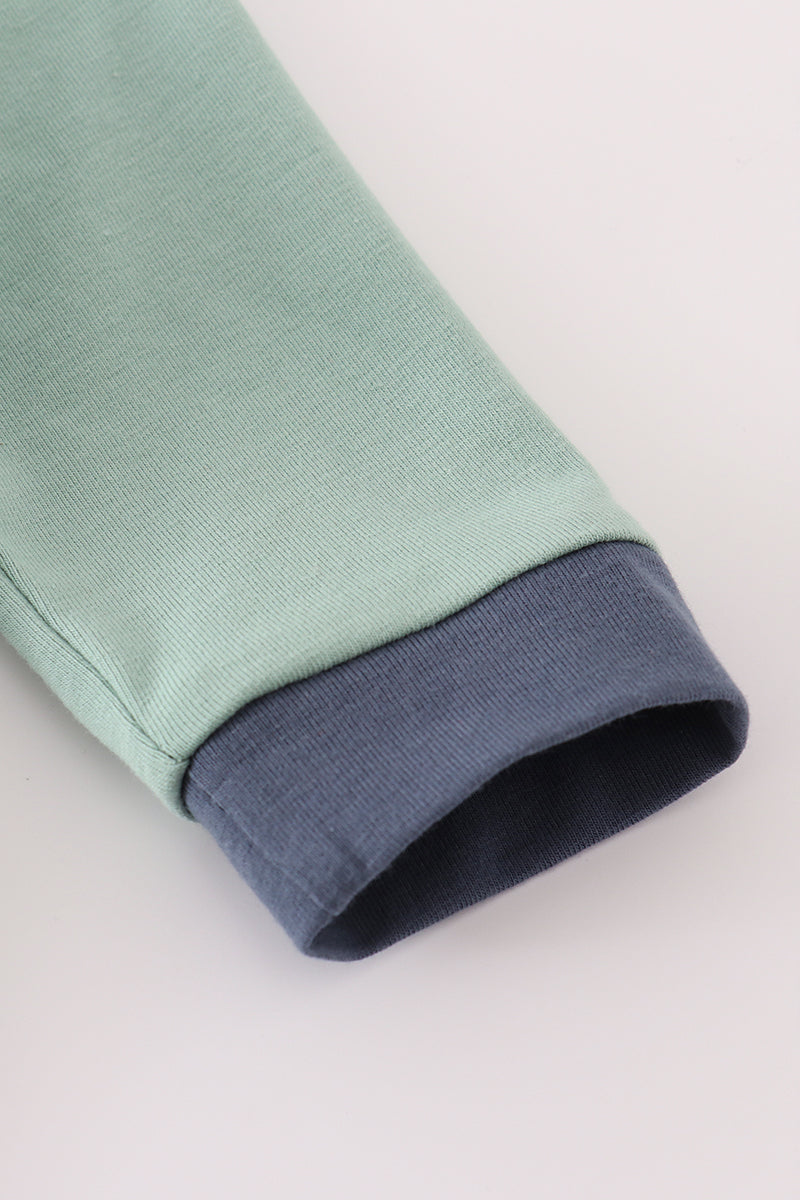 Close-up of a green fabric with a blue inner lining on a white background