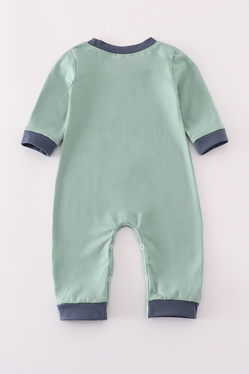 Green baby onesie with dark blue trim on a light gray background