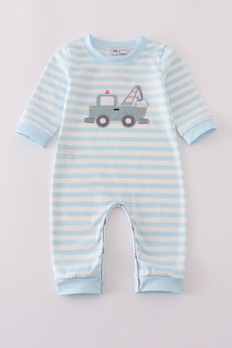 Blue and white striped baby romper with a toy truck design on a light gray background