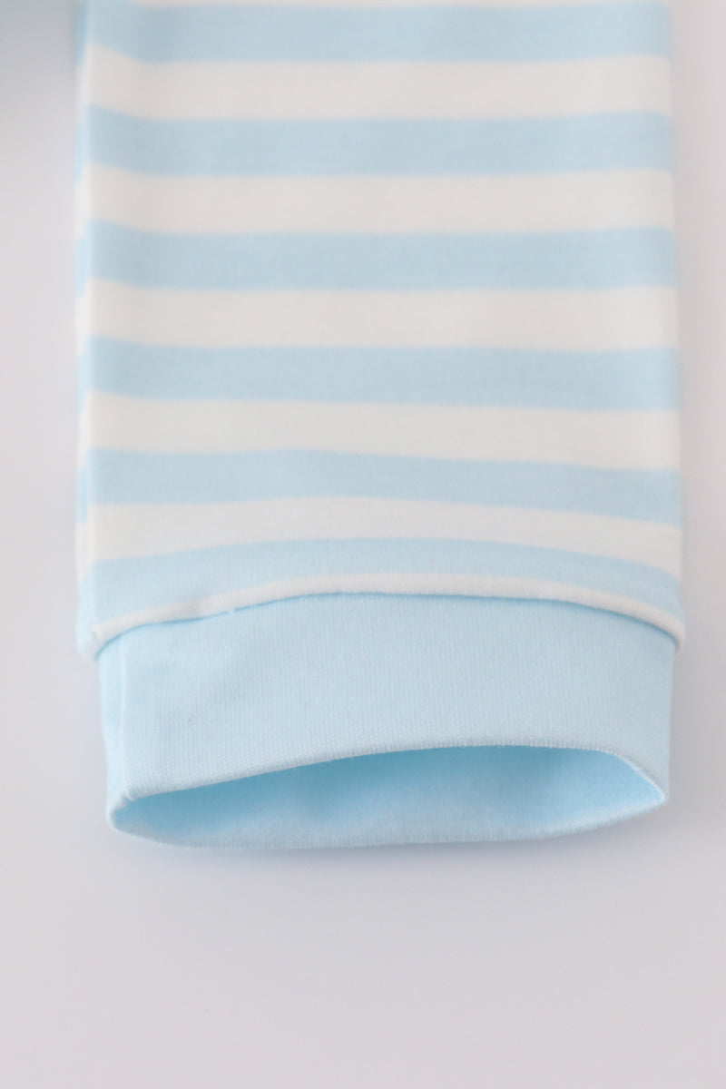 Folded fabric with blue and white horizontal stripes on a light gray background