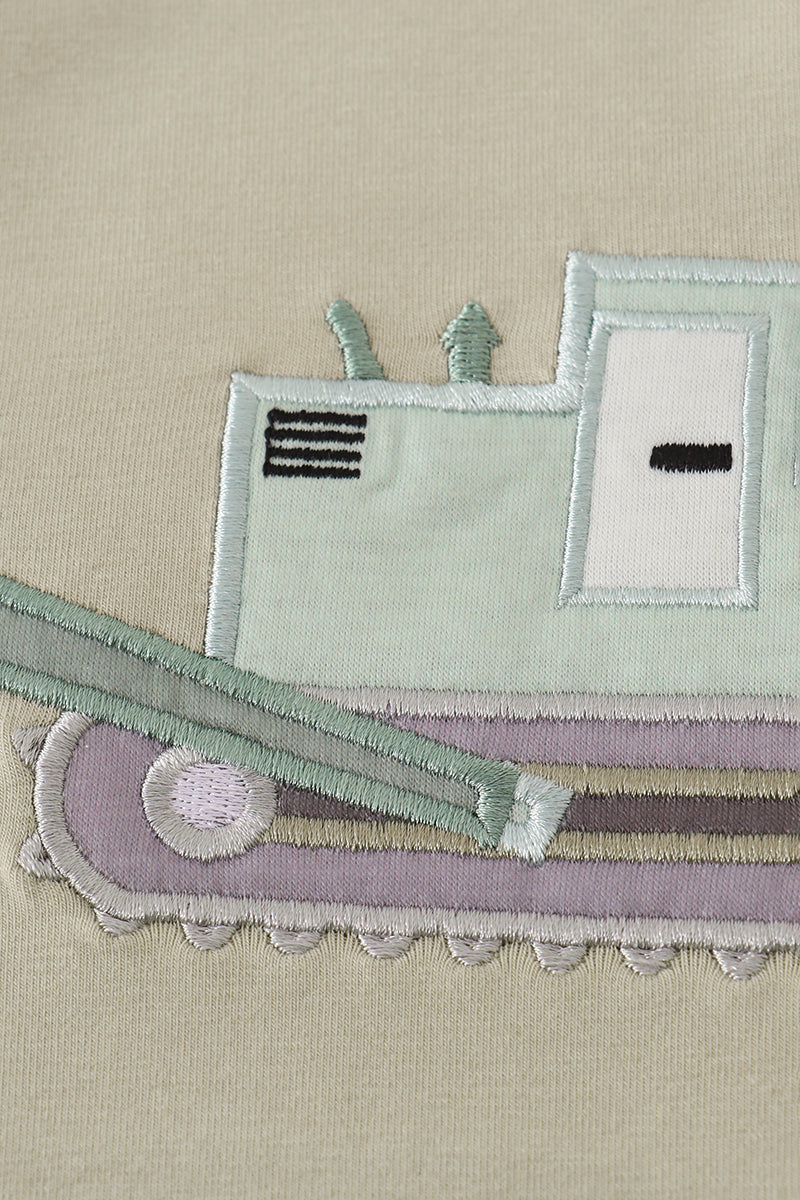 Close-up of a fabric toy with a train design on a beige background